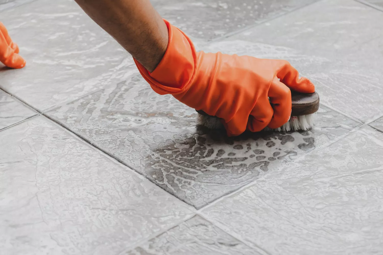 woman scrubbing floor with brush