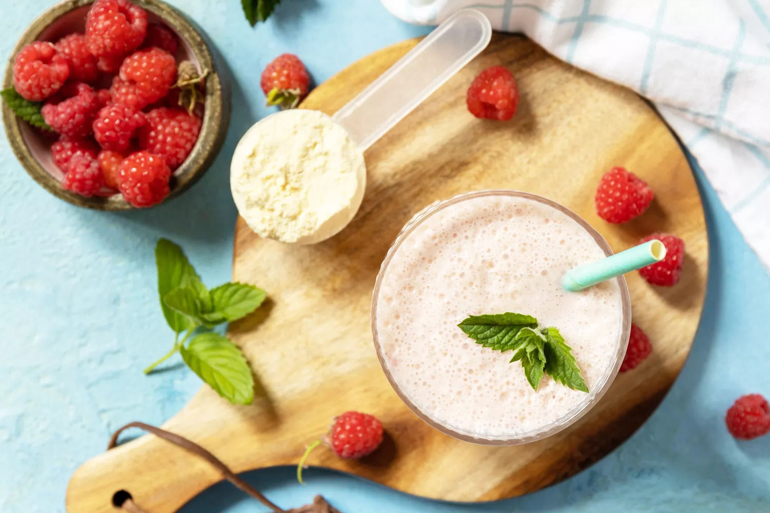 Fresh milk, raspberries drink on wooden board on a stone background, protein shake with fresh berries